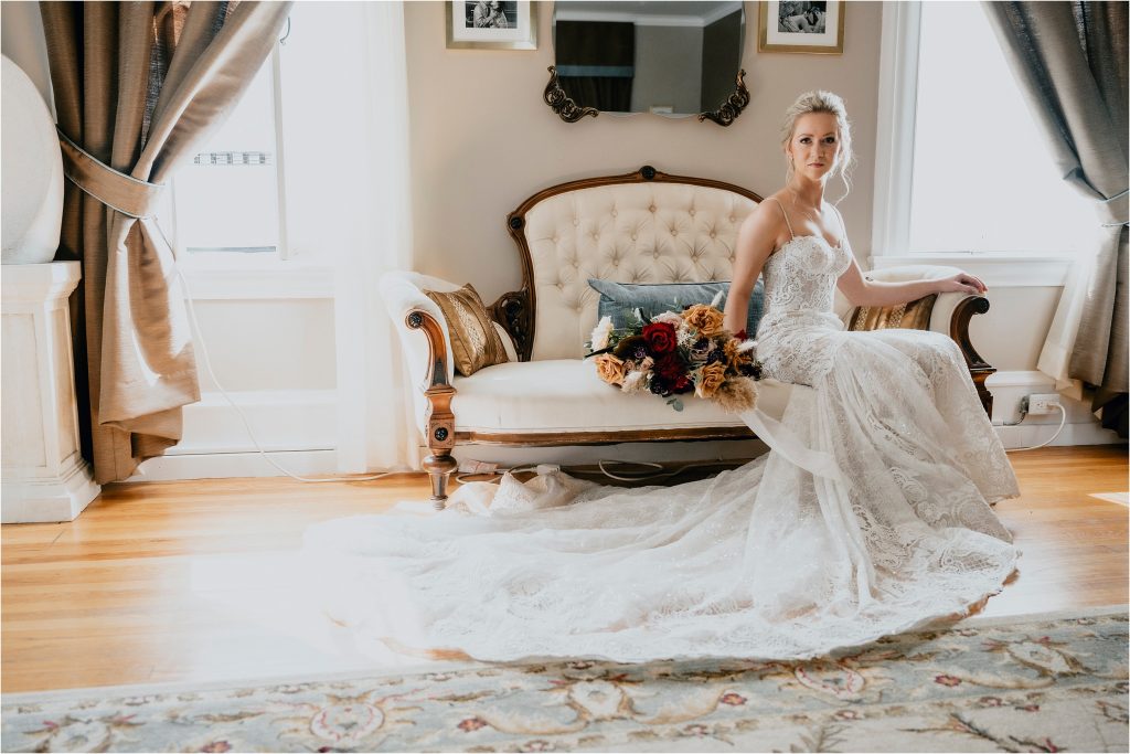 Bride posing on a white couch in Grey Gables Inn Pembroke