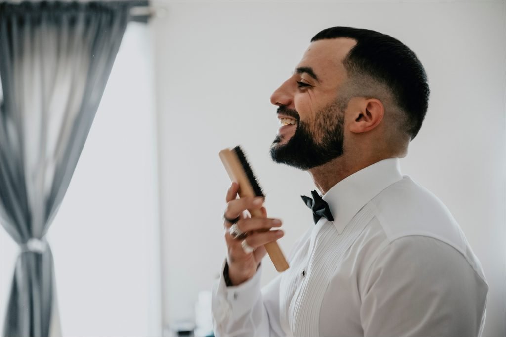 Groom brushing his beard before the wedding.