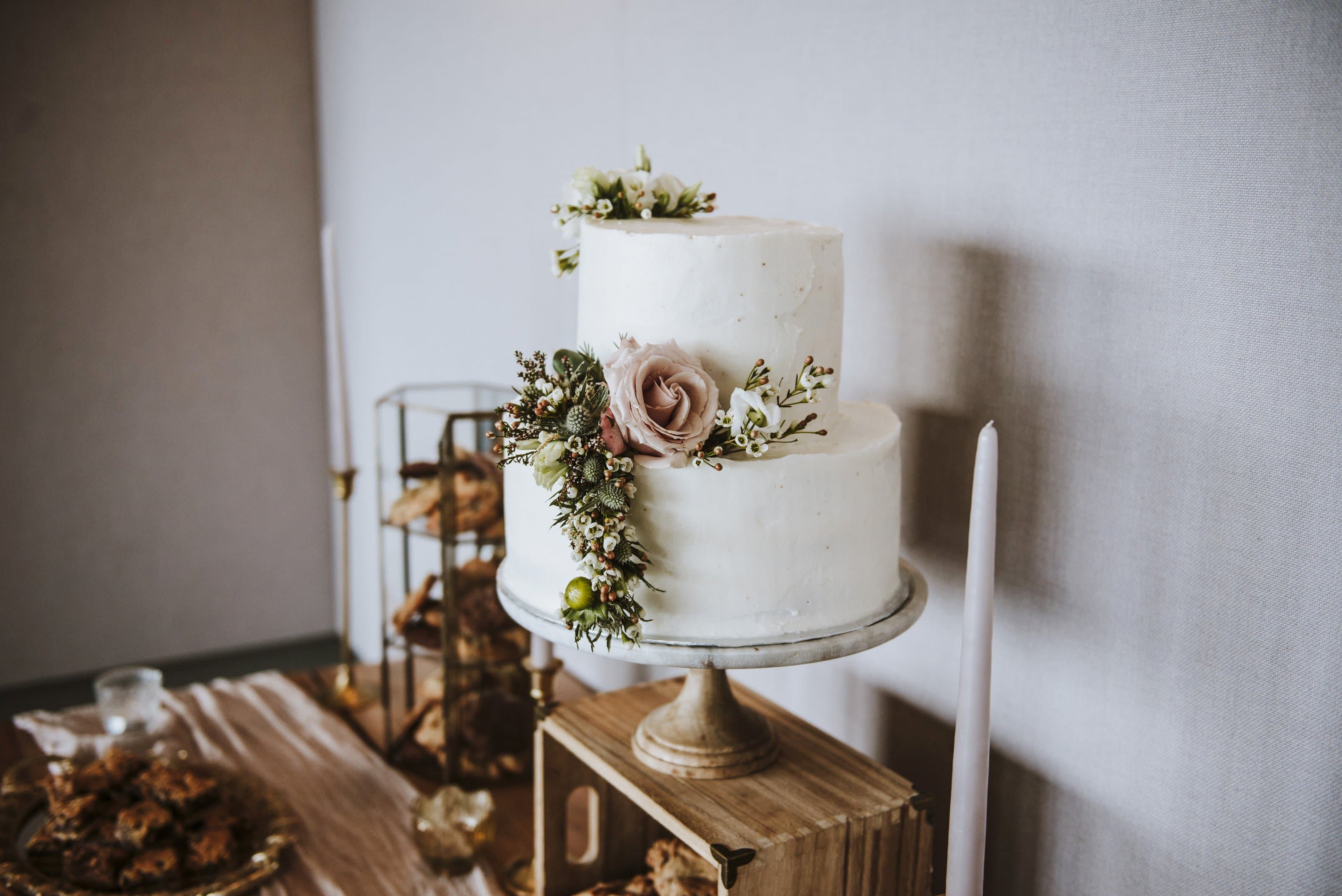 Elegant 2-tier vanilla cake with stunning greenery and flowers.