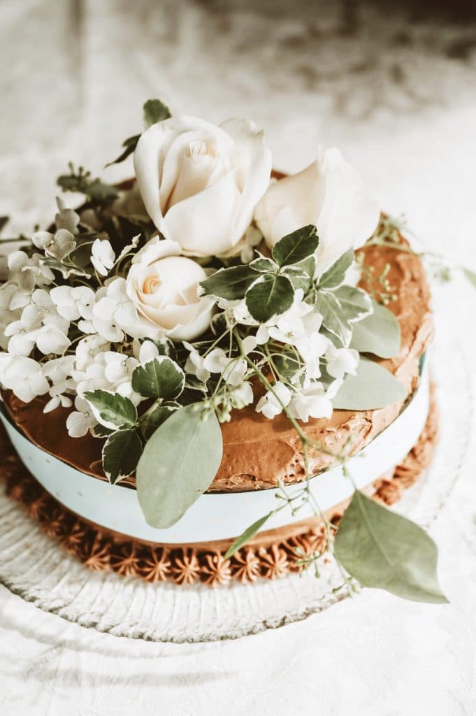Small Chocolate Cake with Blue Ribbon and White Flowers