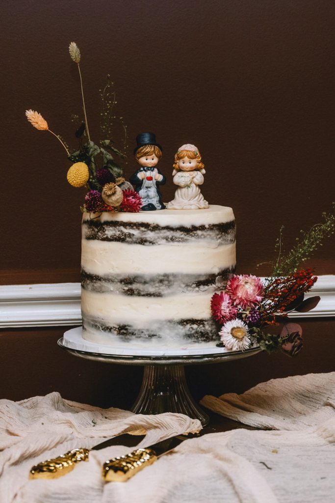 Small Chocolate Cake with Vintage Bride & Groom Toppers and Colorful Dried Flowers. Photo by Cindy Lottes Photography