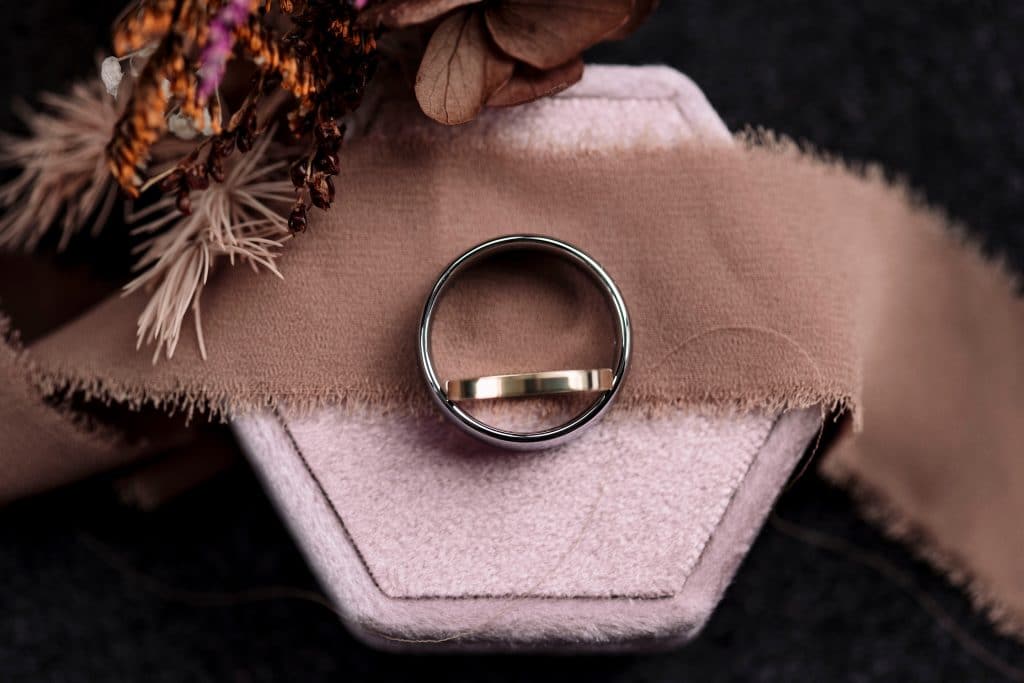 a close-up of wedding bands on a pink ring box
