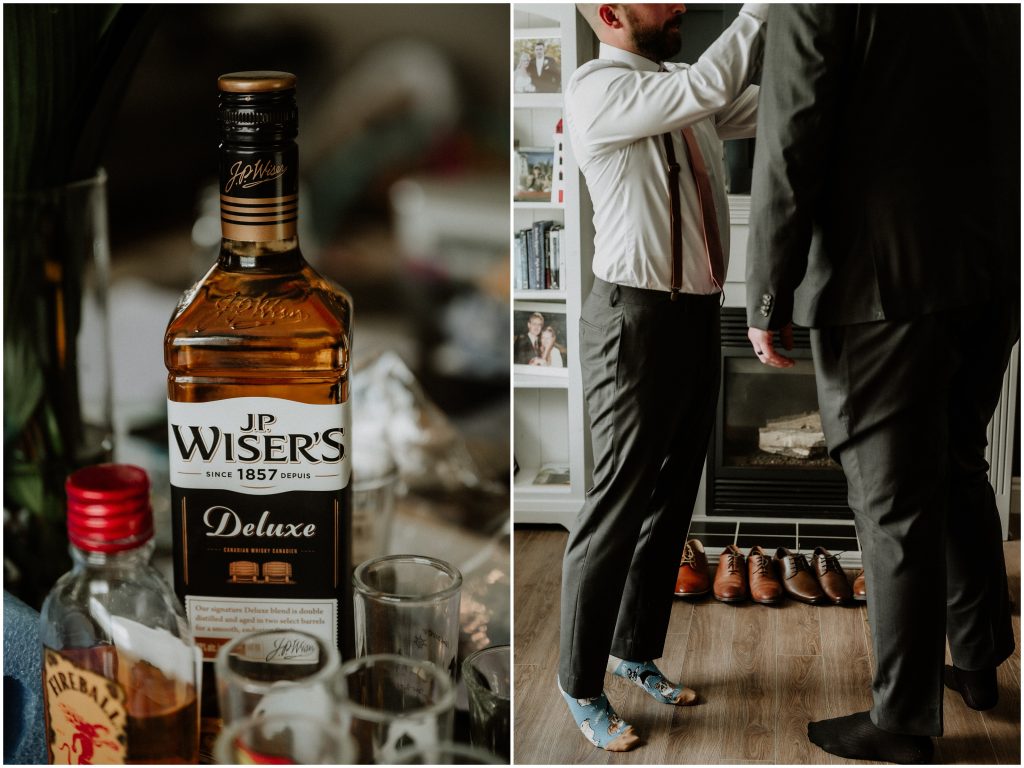A bottle of JP Wiser's and two groomsmen getting dressed before the wedding ceremony. Photo by Cindy Lottes Photography