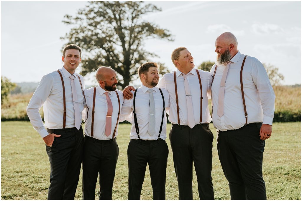 A groom surrounded by his taller groomsmen. Photo by Cindy Lottes Photography