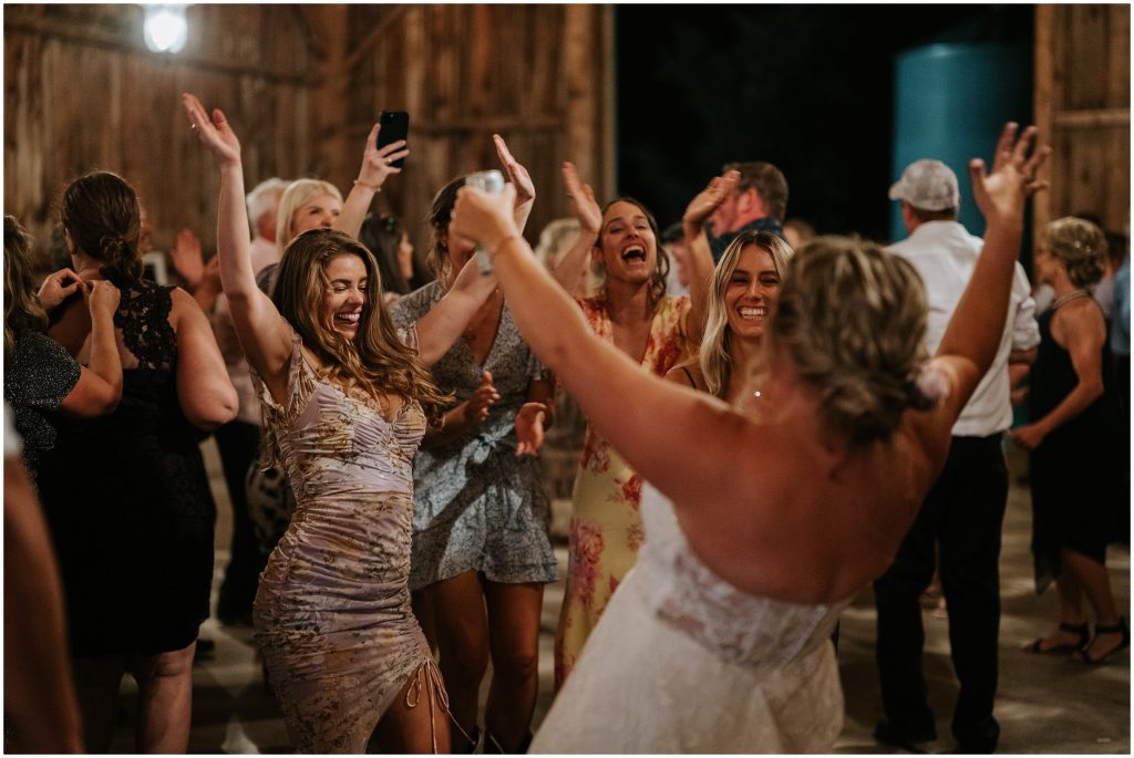 Wedding guests dancing during a barn wedding reception in Braeside. Photo by Cindy Lottes Photography