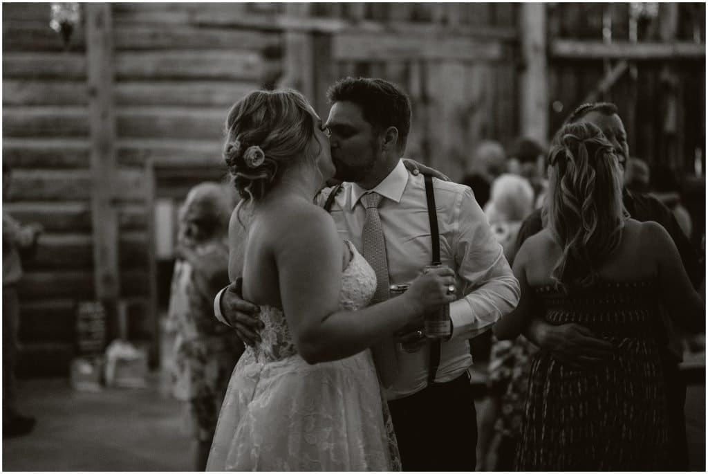 a black and white photo of a bride and groom kissing on the dancefloor. Photo by Cindy Lottes Photography