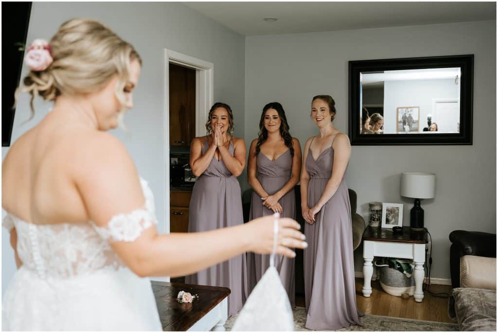 Bridesmaids reaction seinge the bride for the first time in her wedding dress. Photo by Cindy Lottes Photography
