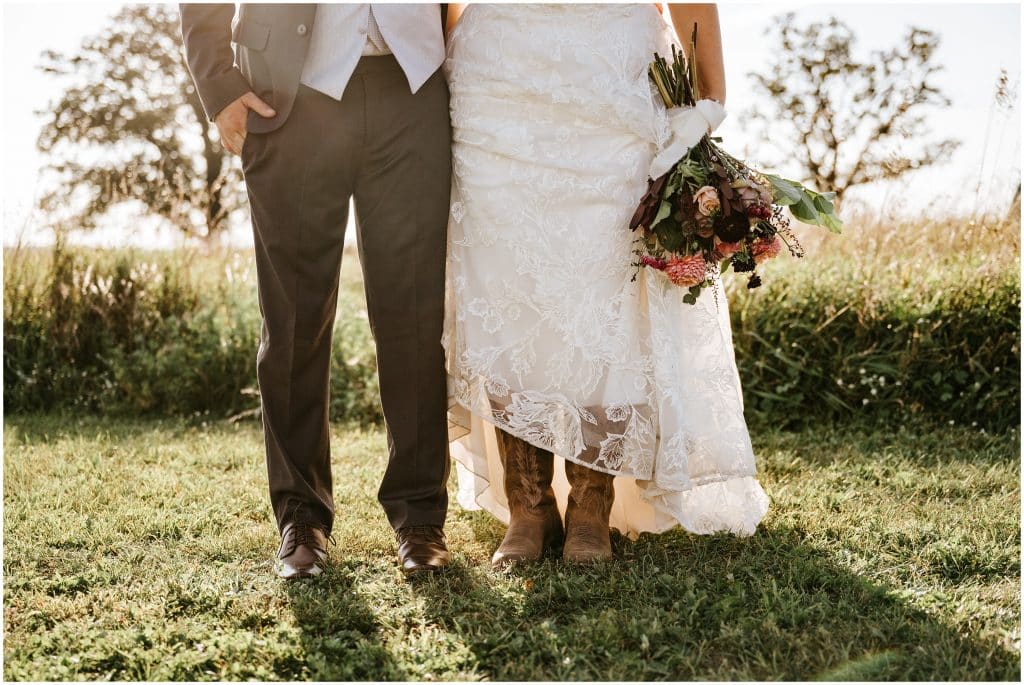 A picture of the lower half of a bride and groom, showing off the brown leather shoes and cowgirl boots. Photo by Cindy Lottes Photography
