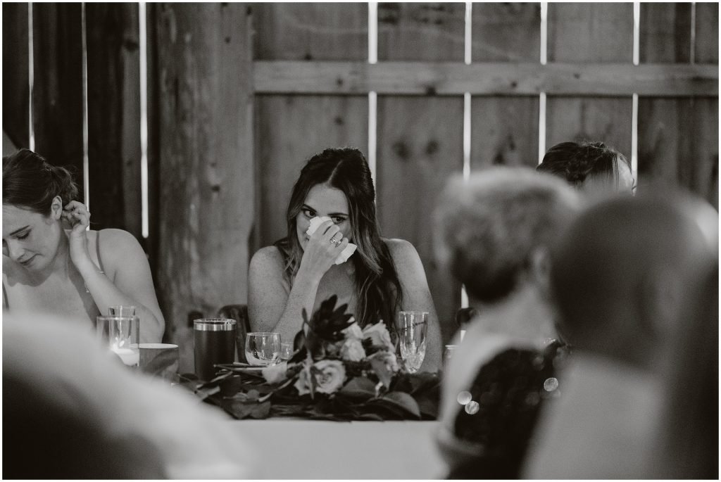 A bridesmaid wipes tears from her eyes during speeches. Photo by Cindy Lottes Photography