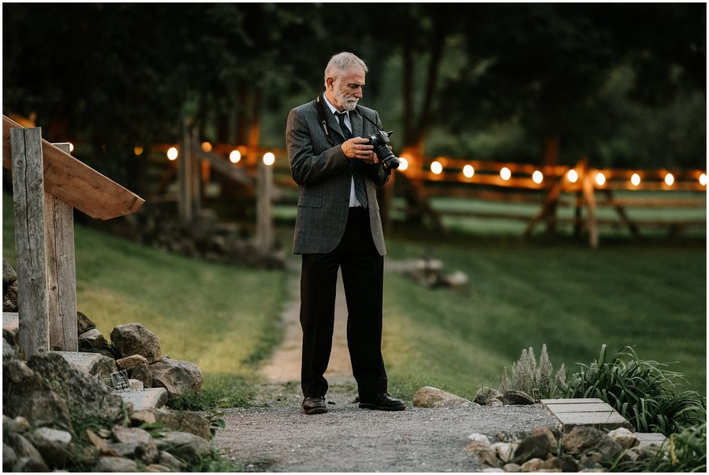 A wedding guest looks at a photo on the back of his camera during the reception.