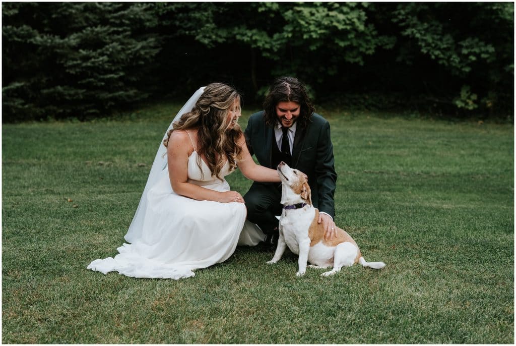 Cody & Kathryn pet their dog on their wedding day.