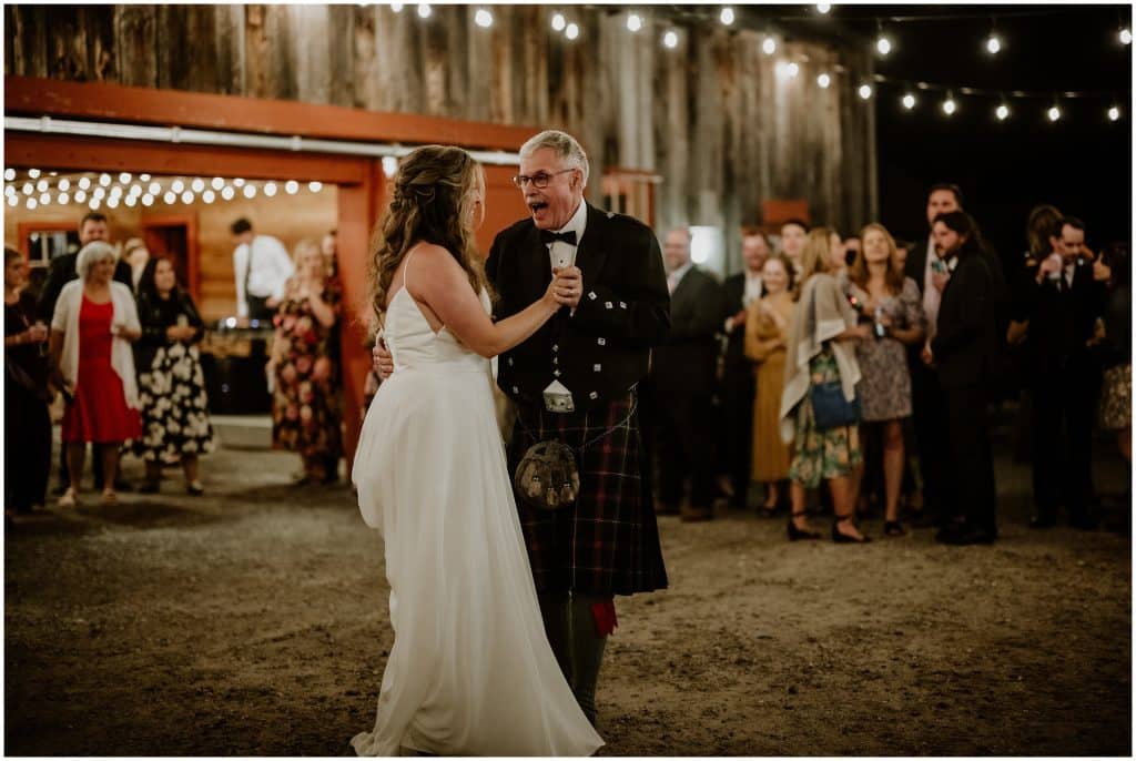 Kathryn dances with her father under twinkle lights at Ecotay wedding venue.